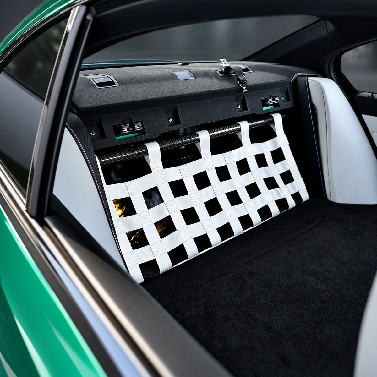 BMW G80 M3 rear seat delete installation with white cargo net; photograph retouched for presentation.