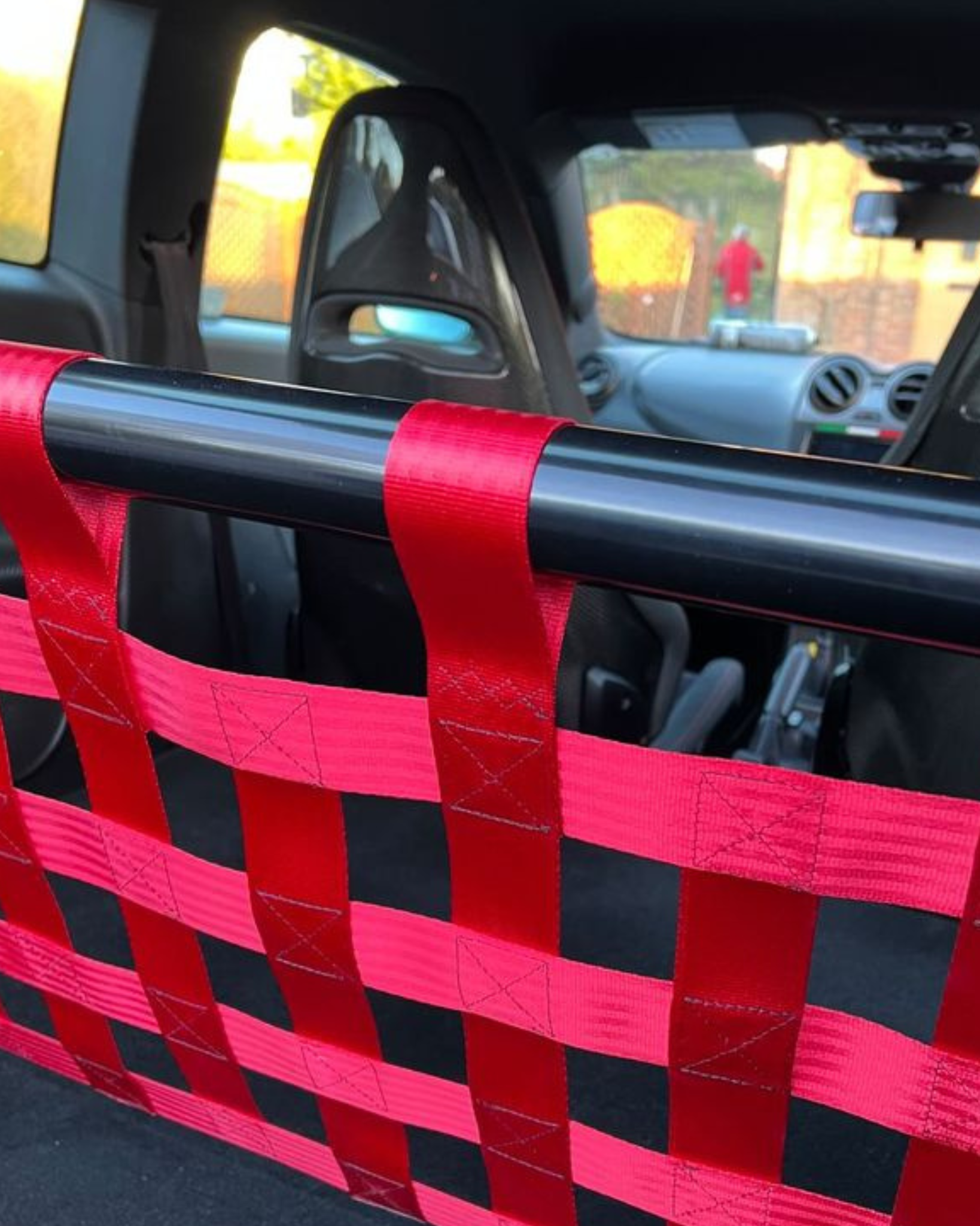 Close-up of a gloss bar with red cargo net webbing and stitched attachment loops.