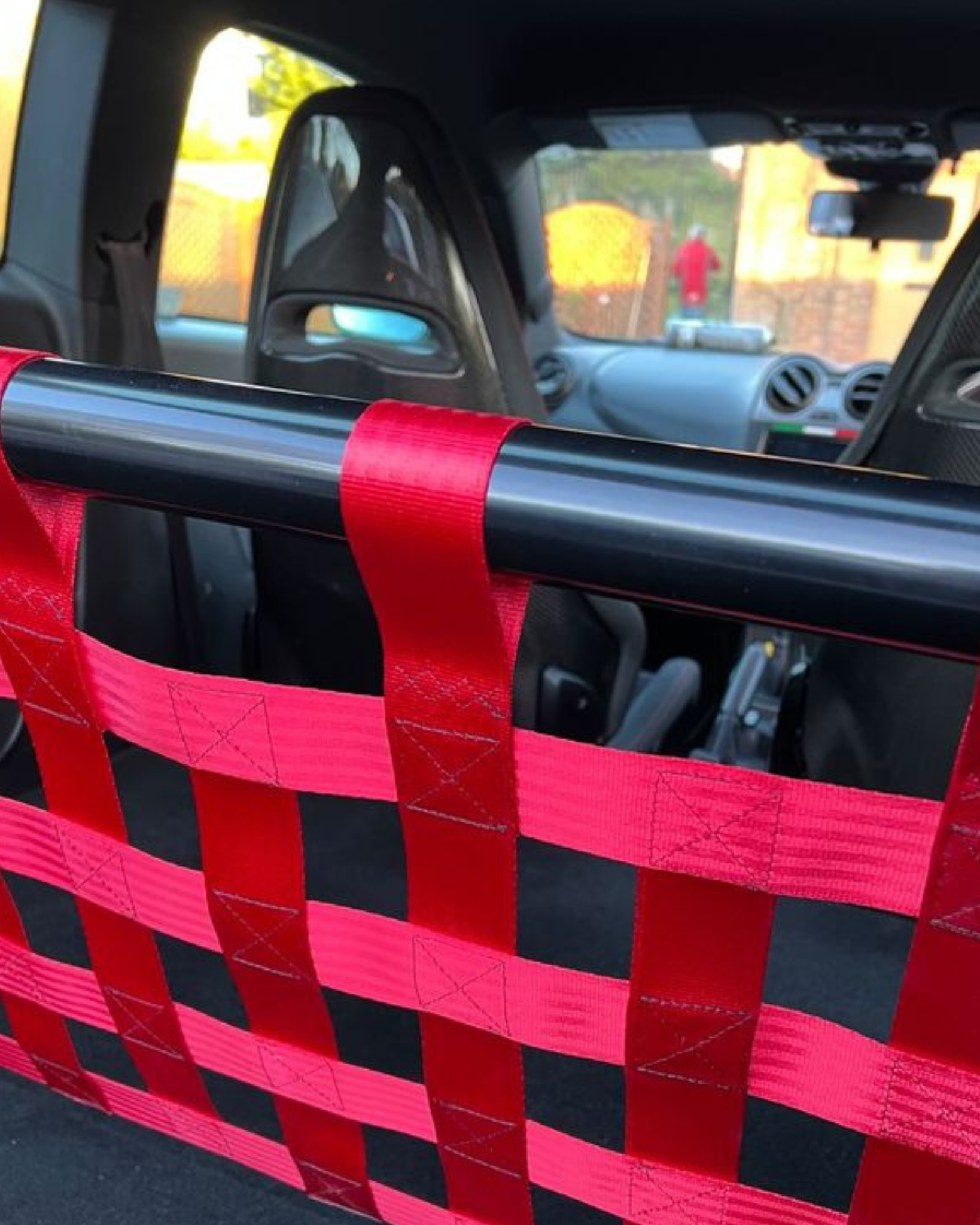 Close-up of a gloss bar with red cargo net webbing and stitched attachment loops.